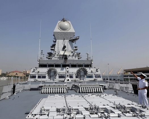 An Indian Navy personnel gestures on the deck of the newly built INS Kochi during a media tour at the naval dockyard in Mumbai